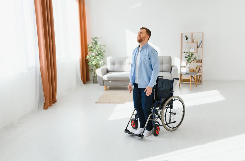 MS patient standing with help of therapy